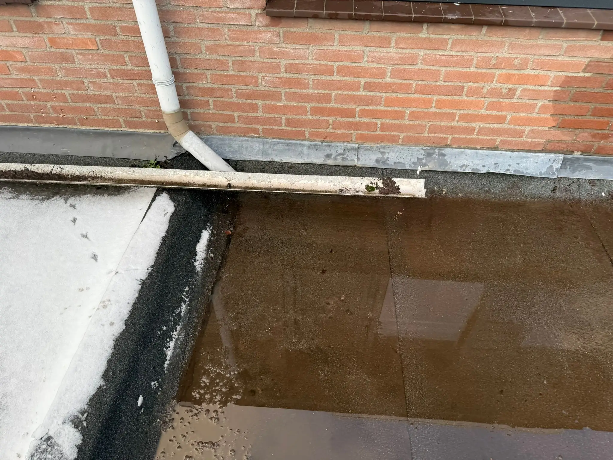 Stormschade aan een dak met losse dakpannen en beschadigd loodwerk na zware storm